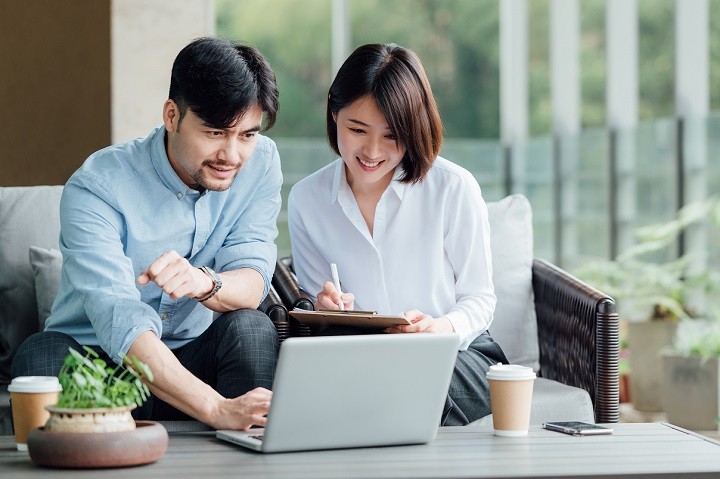 Two colleagues looking at a laptop