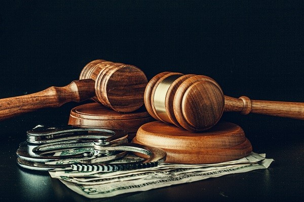 Banknotes, handcuffs, gavel and sound block