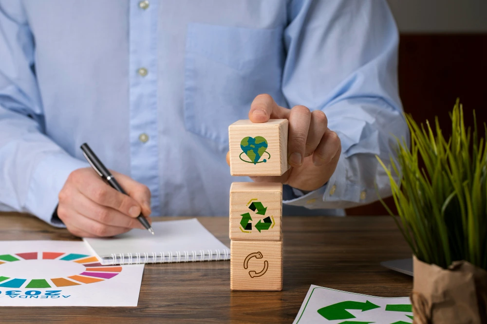 A business professional planning to adopt ESG initiatives by stacking wooden blocks with sustainability and recycling icons on a desk.