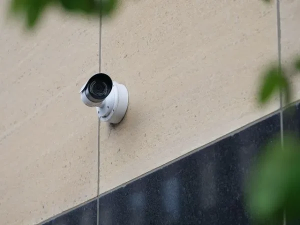Modern CCTV camera mounted on a city building wall for security monitoring.