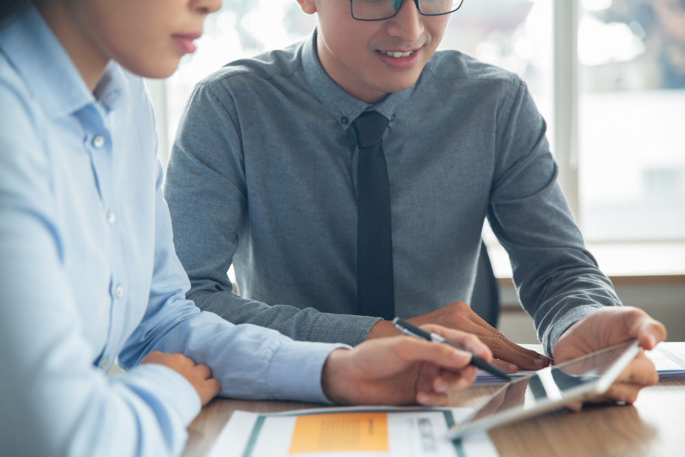 Alder compliance consultant reviewing AML policy procedures and regulatory frameworks with a client