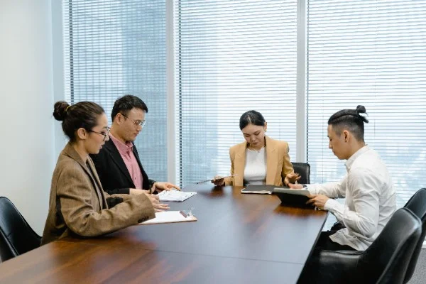 Professional financial advisory team reviewing MAS licence compliance documents in a conference room