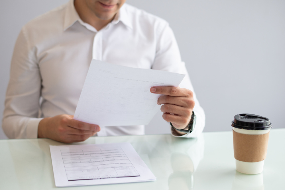 Financial executive conducting deep-dive audit on bespoke MAS compliance manual documents at desk