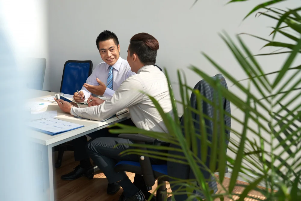 singapore-egc-consulting Two business professionals discussing ESG compliance during a consulting meeting.