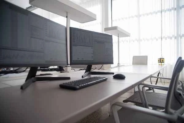 Modern financial trading desk setup with market data monitors for an accredited fund management company in Singapore